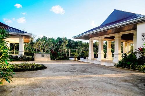 Un gran edificio blanco con columnas y una entrada para vehículos. en Carmel Retreat, en San Pablo