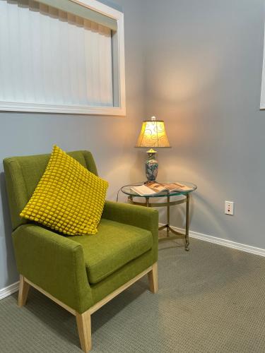 a green chair with a yellow pillow next to a table at Whispering Pines Farmhouse in Redmond