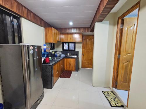 a kitchen with wooden cabinets and a stainless steel refrigerator at 3BR - 4BR Family Transient in Baguio