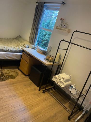 1 dormitorio con escritorio, 1 cama, escritorio y ventana en Cosy Room4 in London Kings Cross, en Londres