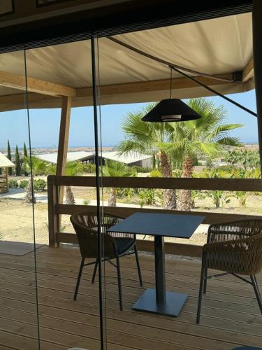 a table and chairs under an umbrella on a deck at Terreforti Luxury Village in Agrigento