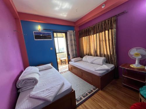 a room with two beds and a window at Kathmandu Valley View Homestay in Kathmandu