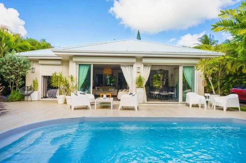 une villa avec piscine devant une maison dans l'établissement Villa Cava, à Baie-Mahault