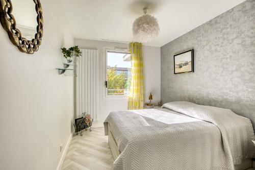 une chambre blanche avec un lit et une fenêtre dans l'établissement Appartement Dolce Vita - Your ideal getaway in the heart of Annecy, à Annecy