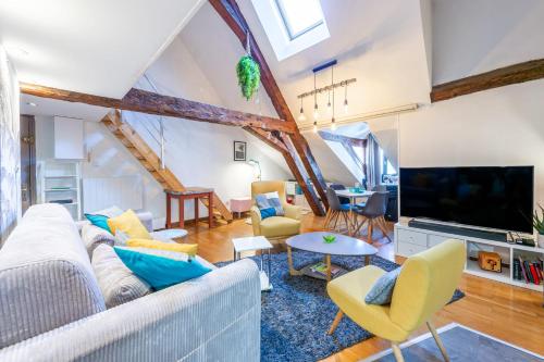 un salon avec un canapé et une télévision dans l'établissement La Mansarde - Duplex au bord du lac, à Annecy