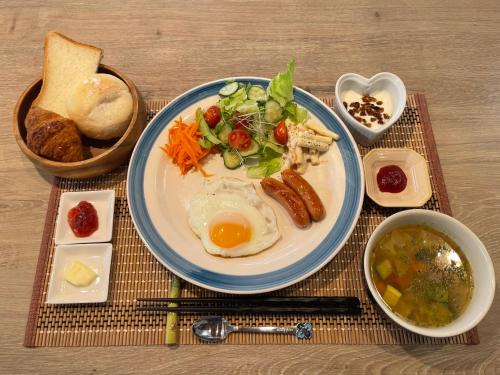 a plate of food with an egg on a table at オホーツクの海の幸が食べられる 漁師の家ゲストハウスOhana in Abashiri