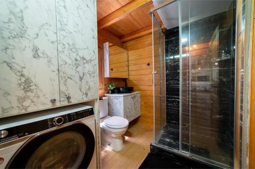 a bathroom with a toilet and a glass shower at Ktima To Alliotiko - Lofou in Lofou