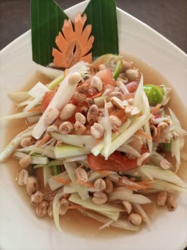 a white plate of food with vegetables and nuts at Khao Sok Country Resort in Khao Sok