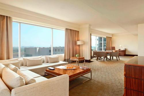 a living room with a white couch and a large window at The Westin Pune Koregaon Park in Pune