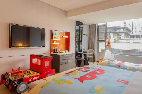 a bedroom with a bed and a tv on the wall at DoubleTree By Hilton Cangnan in Cangnan