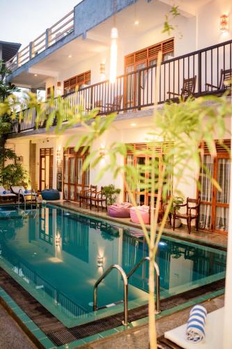 a house with a swimming pool in front of a building at Bienvenido Cozy Madiha in Matara