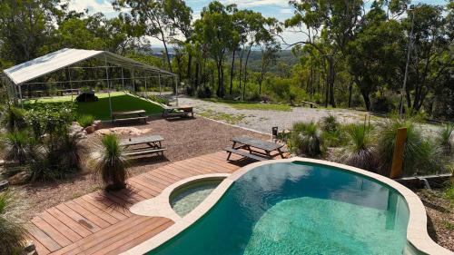 una piscina en una terraza de madera junto a una casa en 1770 Eco Camp, en Agnes Water