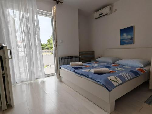 a bedroom with a bed and a large window at Apartments & Rooms Samohod in Vodice