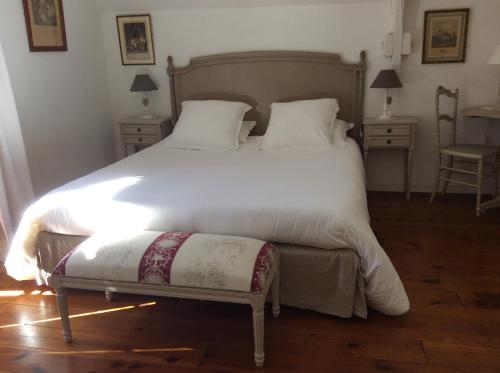 une chambre avec un grand lit blanc avec deux tables dans l'établissement Le gîte de Cathy-Charmant cottage en centre-ville, à Vannes