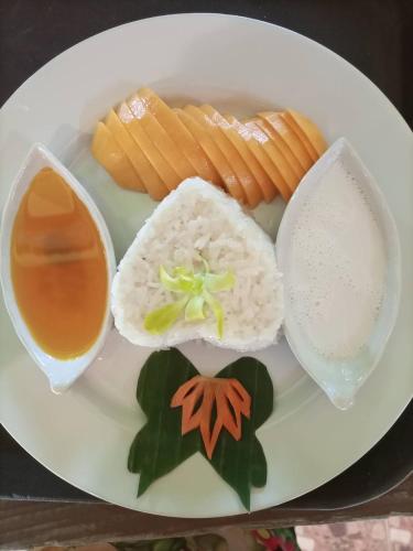 a plate of food with rice and carrots and a drink at Khao Sok Country Resort in Khao Sok