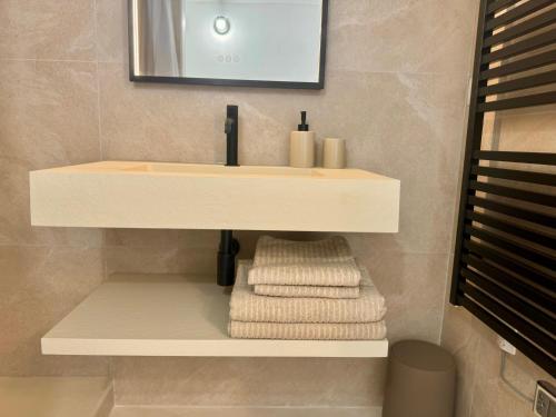 a bathroom with a sink and towels on a shelf at Studio design - Coup de coeur in Antibes