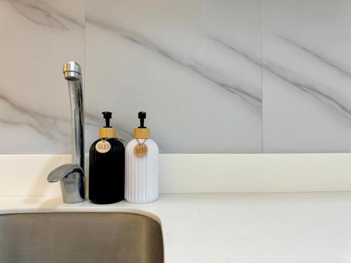 two soap bottles sitting on top of a sink at Peridot Haven PH in Lagundi