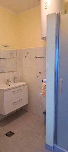 a white bathroom with a sink and a toilet at Apartment Rose in Koper