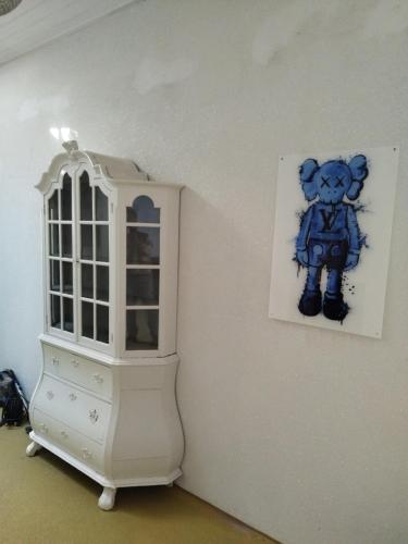 a painting of a teddy bear on a wall next to a cabinet at Happy in Deventer in Deventer