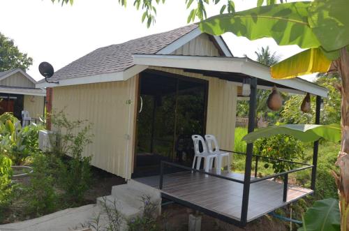 a gazebo with a chair on a wooden deck at Nok Chan Mee Na in Chom Thong