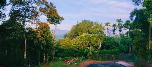 a view of a park with trees and a fence at Vihaara Wayanad Serviced Villa in Ambalavayal