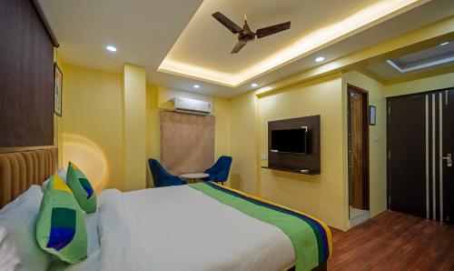 a hotel room with a bed and a ceiling fan at Treebo Taj Square, 10 Mins From Airport in Patna