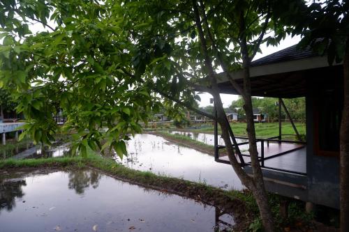 a flooded street in front of a building at Nok Chan Mee Na in Chom Thong
