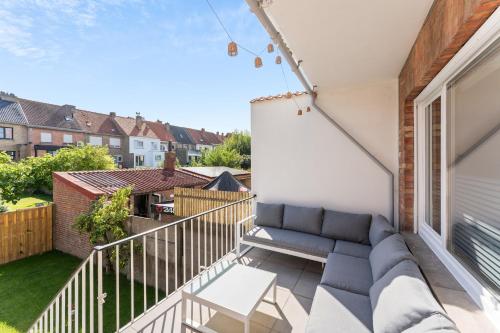 a view from the balcony of a house with a couch at Ruime woning aan zee met zonnige tuin en terras - 9p in Blankenberge