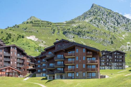 un groupe de bâtiments devant une montagne dans l'établissement Résidence Pierre & Vacances Emeraude, à Belle Plagne