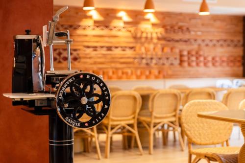 a clock on a pole in a restaurant with chairs at Serra Boutique Hôtel in Agen