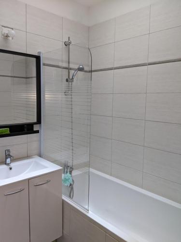 une salle de bain avec une douche, un lavabo et une baignoire dans l'établissement Maison récente, à Chaumes en Retz