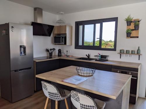 une cuisine avec une table en bois et un réfrigérateur dans l'établissement Maison récente, à Chaumes en Retz