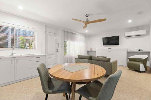 a kitchen and living room with a table and chairs at Moonlight Bay Suites in Broome