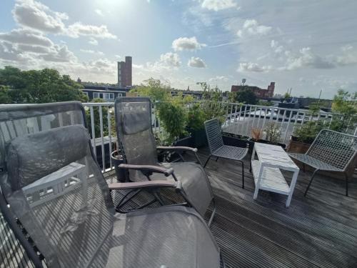 a balcony with chairs and a table on a roof at Designed Penthouse, Amsterdam city center in Amsterdam