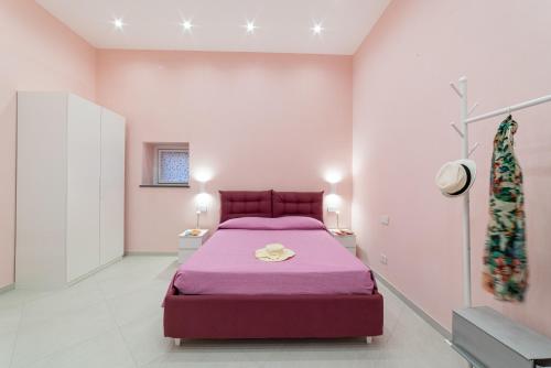 a bedroom with a purple bed in a pink room at La Stella dei venti in Vico Equense