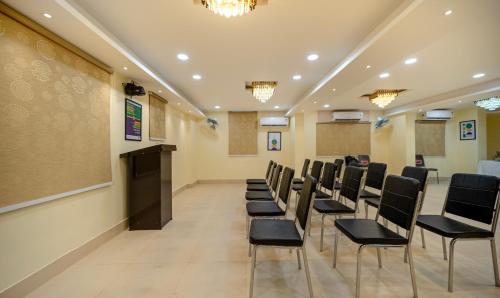 a conference room with black chairs and a podium at Treebo Taj Square, 10 Mins From Airport in Patna
