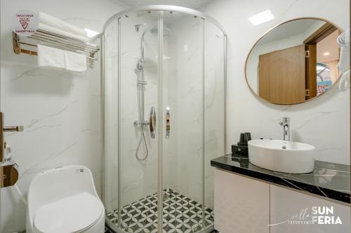 une salle de bain blanche avec une douche et un lavabo dans l'établissement Sun Villa 7 br & pool, à Hạ Long