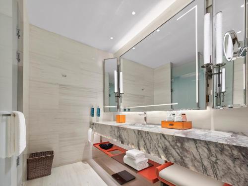 a bathroom with a sink and a large mirror at DoubleTree By Hilton Cangnan in Cangnan