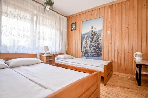 a bedroom with two beds and a window at Rysiówka in Poronin