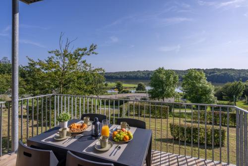 une table avec deux assiettes de nourriture sur un balcon dans l'établissement La Hulotte H26 - Le Val Joly, à Eppe-Sauvage