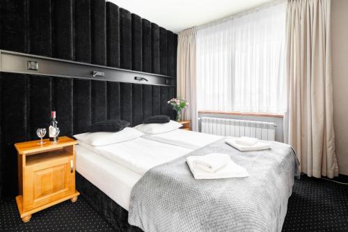 a hotel room with two beds and a window at Tatrzański Dworek in Biały Dunajec