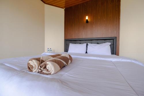 BangliにあるLa Pino Mount Batur and Hot Springのタオルが敷かれたベッドのある寝室