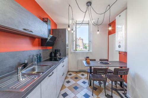 - une cuisine avec un évier et une table dans l'établissement La Halte Parodienne - Appt avec vue sur le canal, à Paray-le-Monial