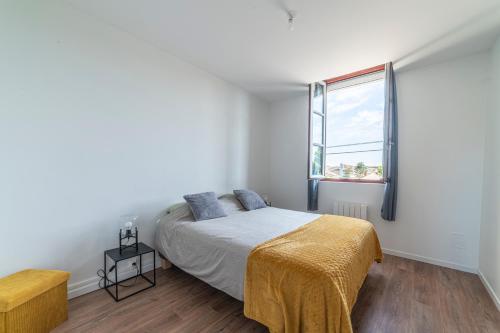 une chambre avec un lit et une grande fenêtre dans l'établissement La Halte Parodienne - Appt avec vue sur le canal, à Paray-le-Monial