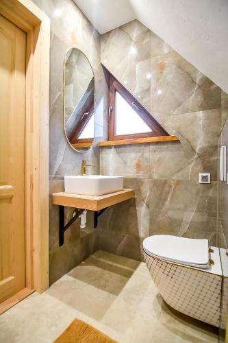 a bathroom with a sink and a mirror at Domek Jatka No 1 in Zakopane