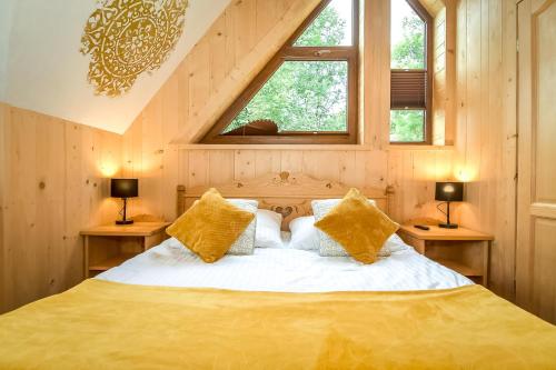 a bedroom with a bed with yellow pillows at Domek Jatka No 1 in Zakopane