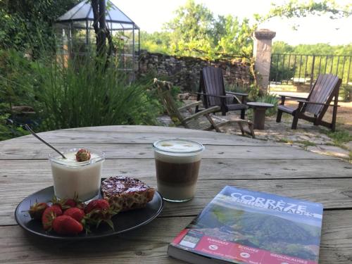 einen Tisch mit einem Teller Essen und einem Buch in der Unterkunft Chez Walter et Camille in Saint-Cernin-de-Larche