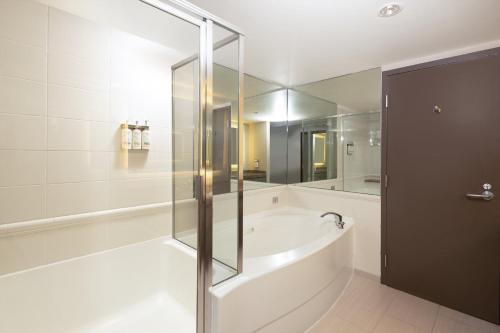 a bathroom with a tub and a glass shower at Holiday Inn Vancouver Airport Richmond by IHG in Richmond