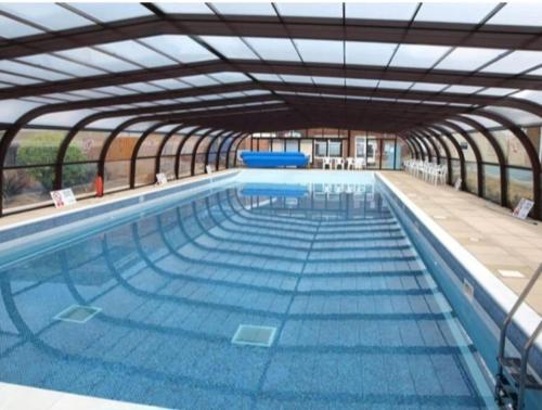 a large swimming pool with an open structure at clifftop villa 47 in Corton