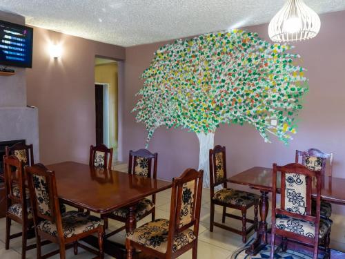 a dining room with a table and a tree at Mopani Lodge Victoria Falls in Victoria Falls